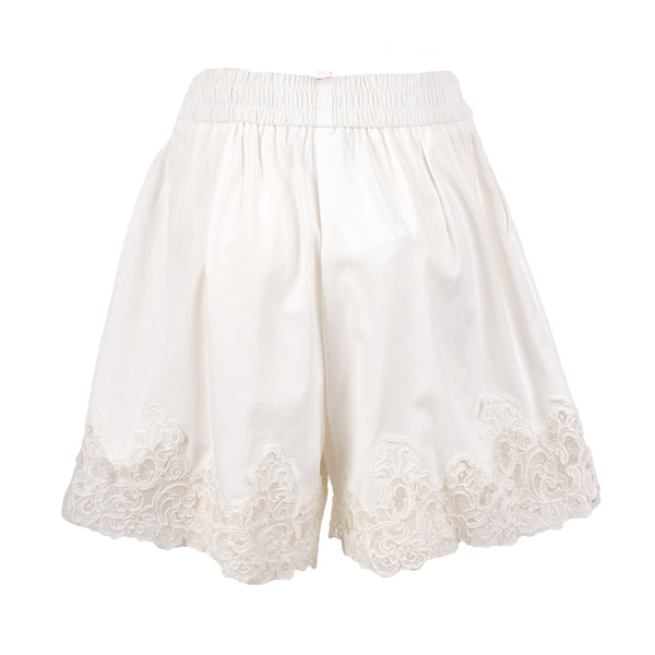 Shorts bianchi con elastiico in vita presentano un delicato orlo smerlato con ricami floreali in pizzo.